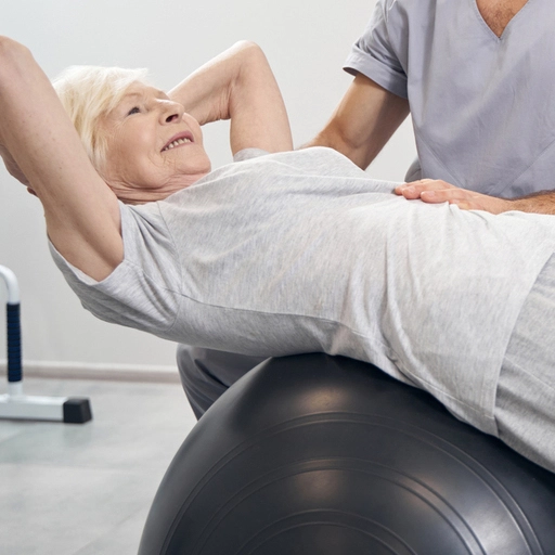 Physiotherapeut unterstützt ältere Patientin bei Übungen
